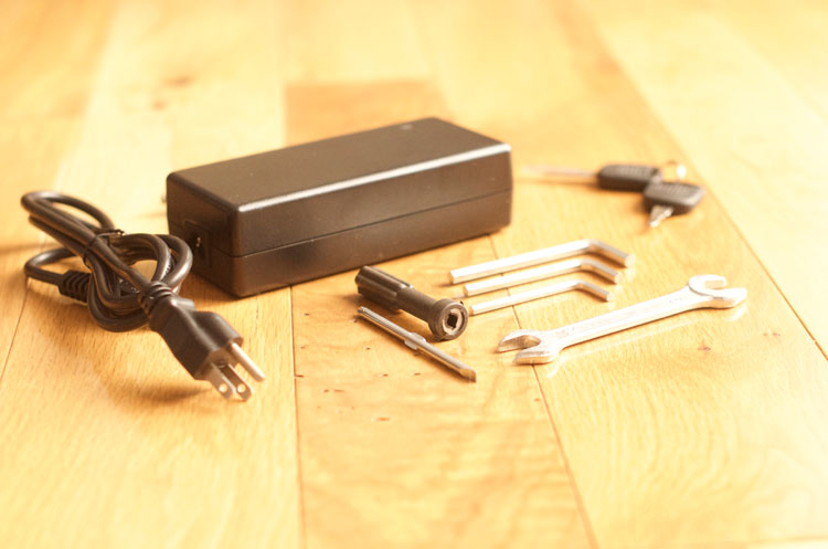 Battery charger, keys, and included bike assembly kit